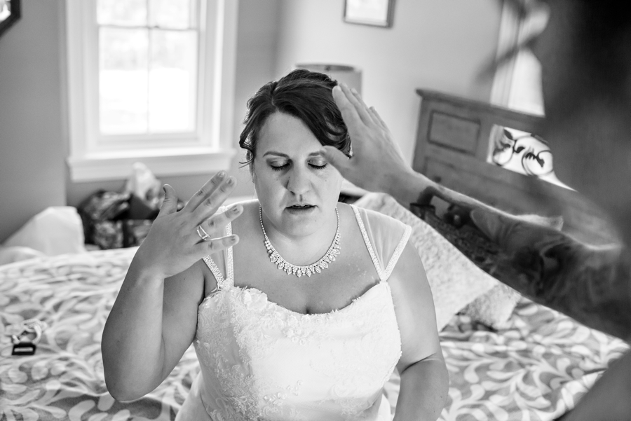 A bride trying not to cry after reading a note from her fiance.